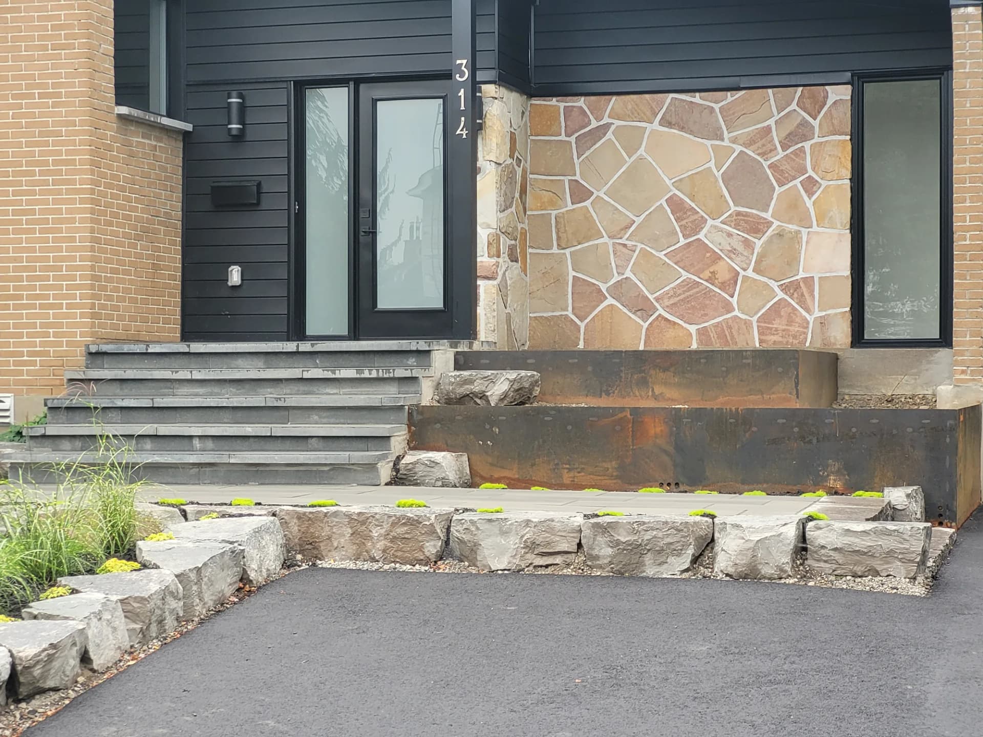 Aménagement d'entrée avec escalier, blocs de pierre naturelle et bordure en acier corten
