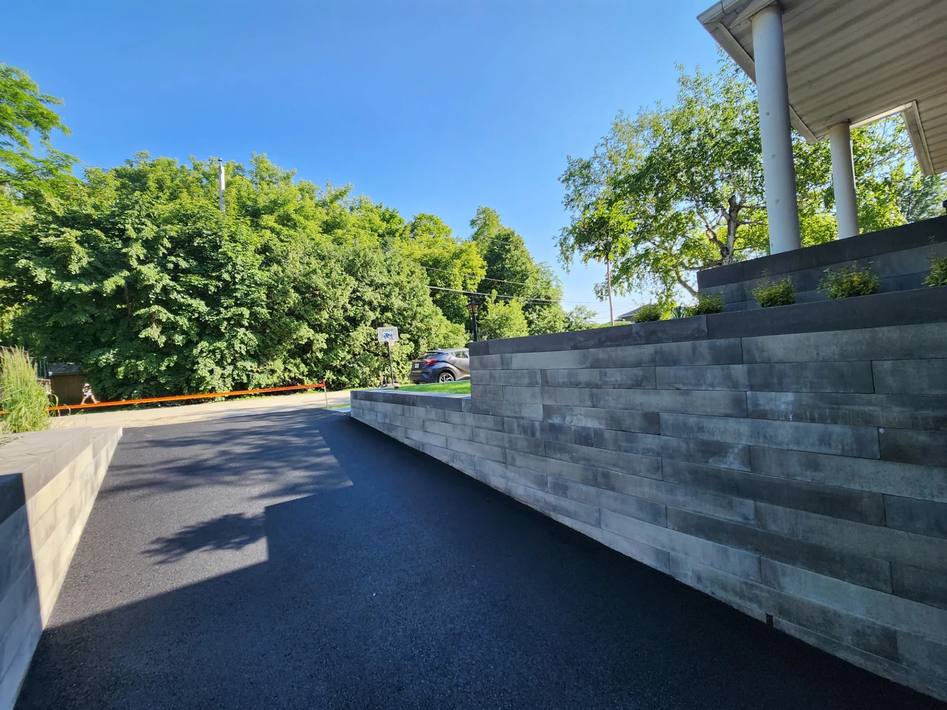 Entrée asphaltée et muret de soutènement en blocs de béton à Brossard