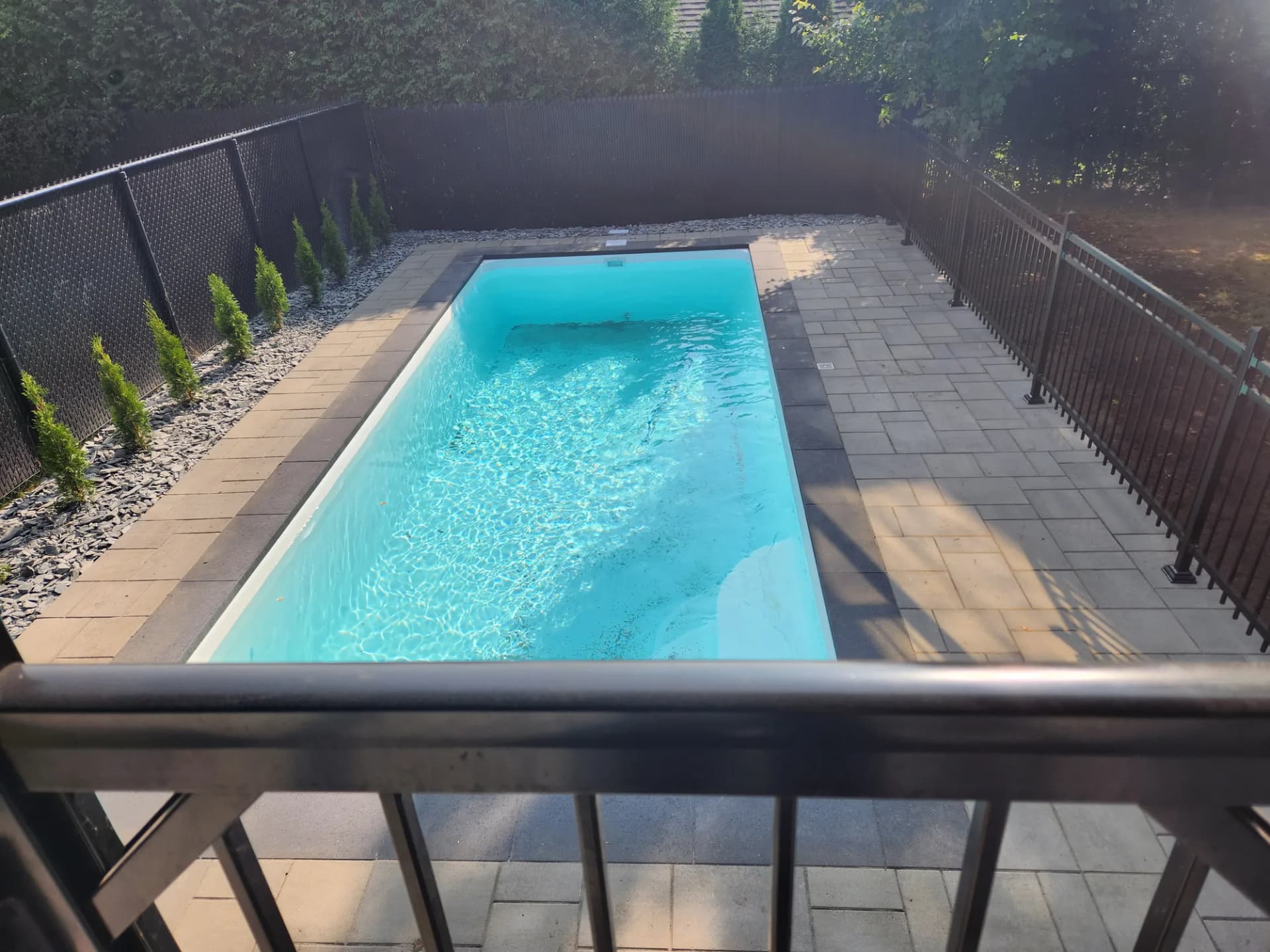 Vue plongeante sur une piscine creusée et son contour en pavé bicolore