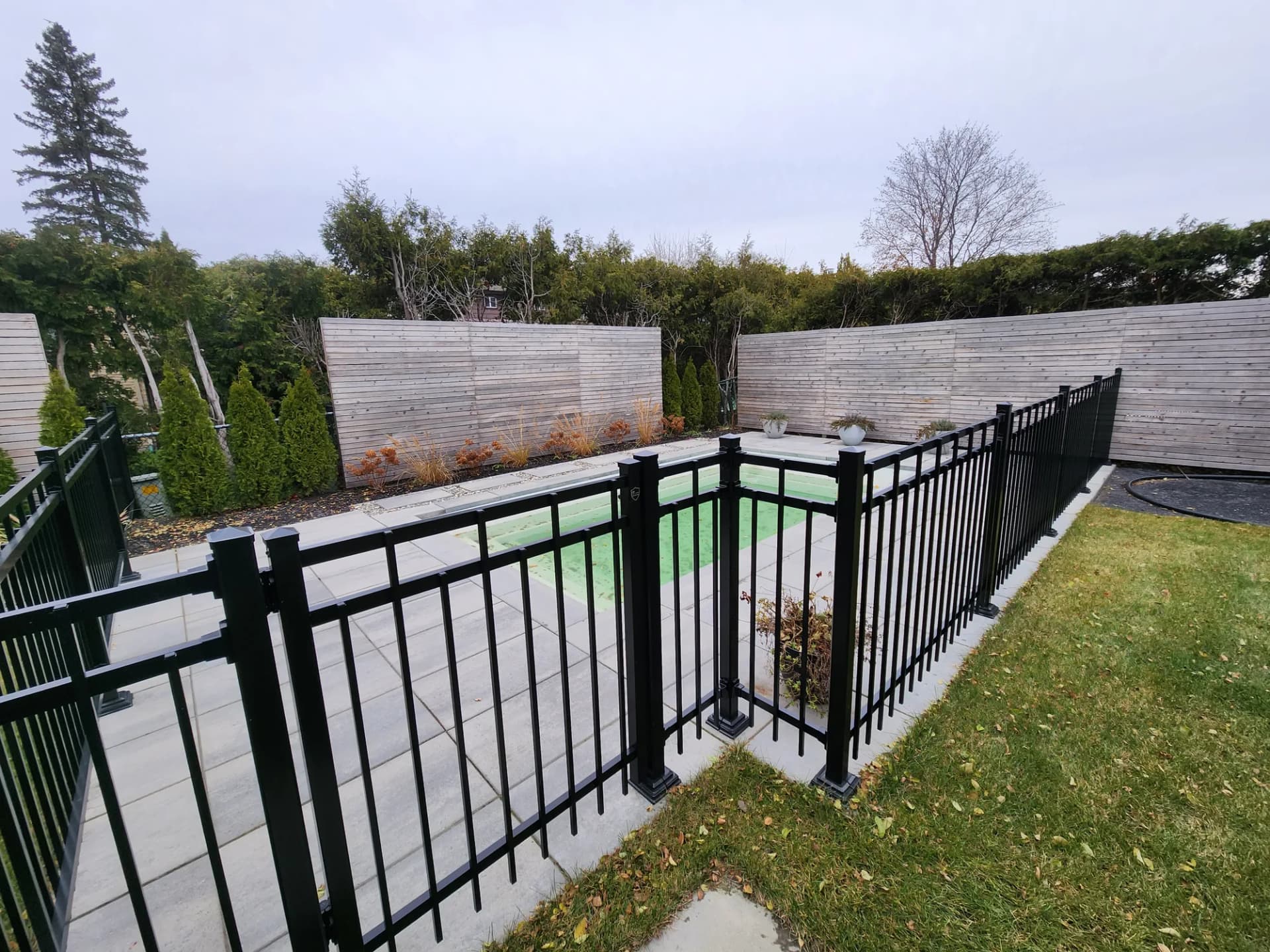 Enceinte de piscine clôturée avec dalles et écrans d'intimité en bois