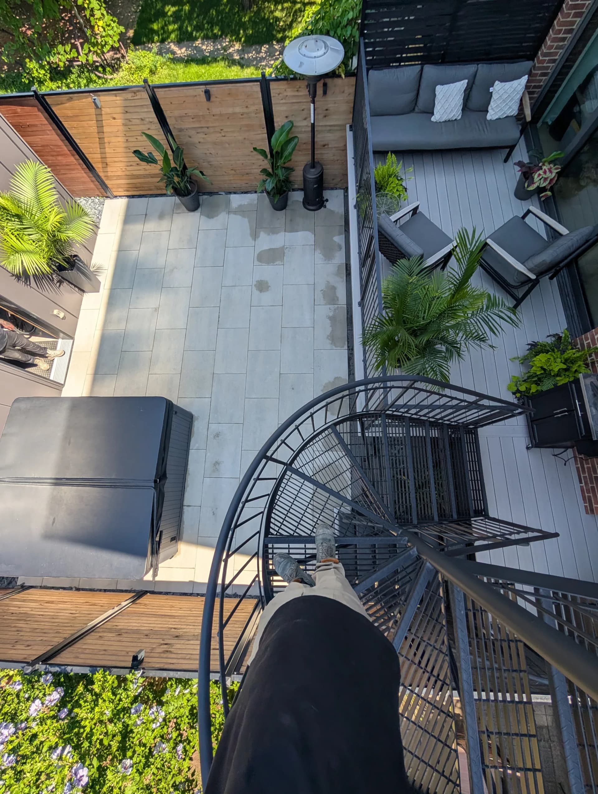 Terrasse sur toit en dalles de porcelaine avec spa et plantes tropicales