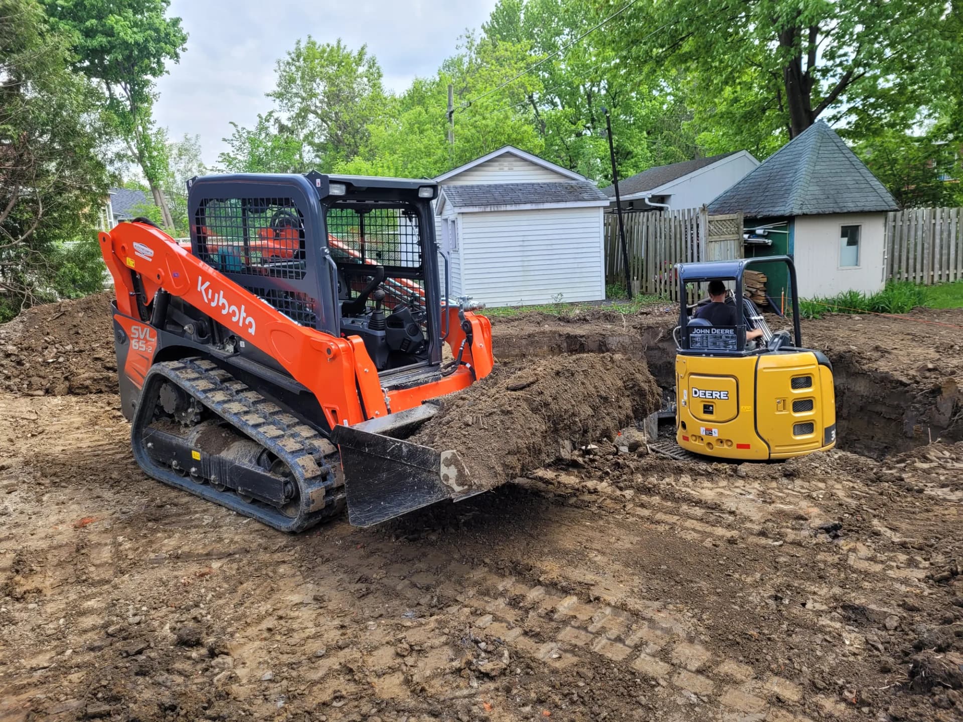 Excavation d'une cour arrière avec chargeuse sur chenilles et mini-pelle