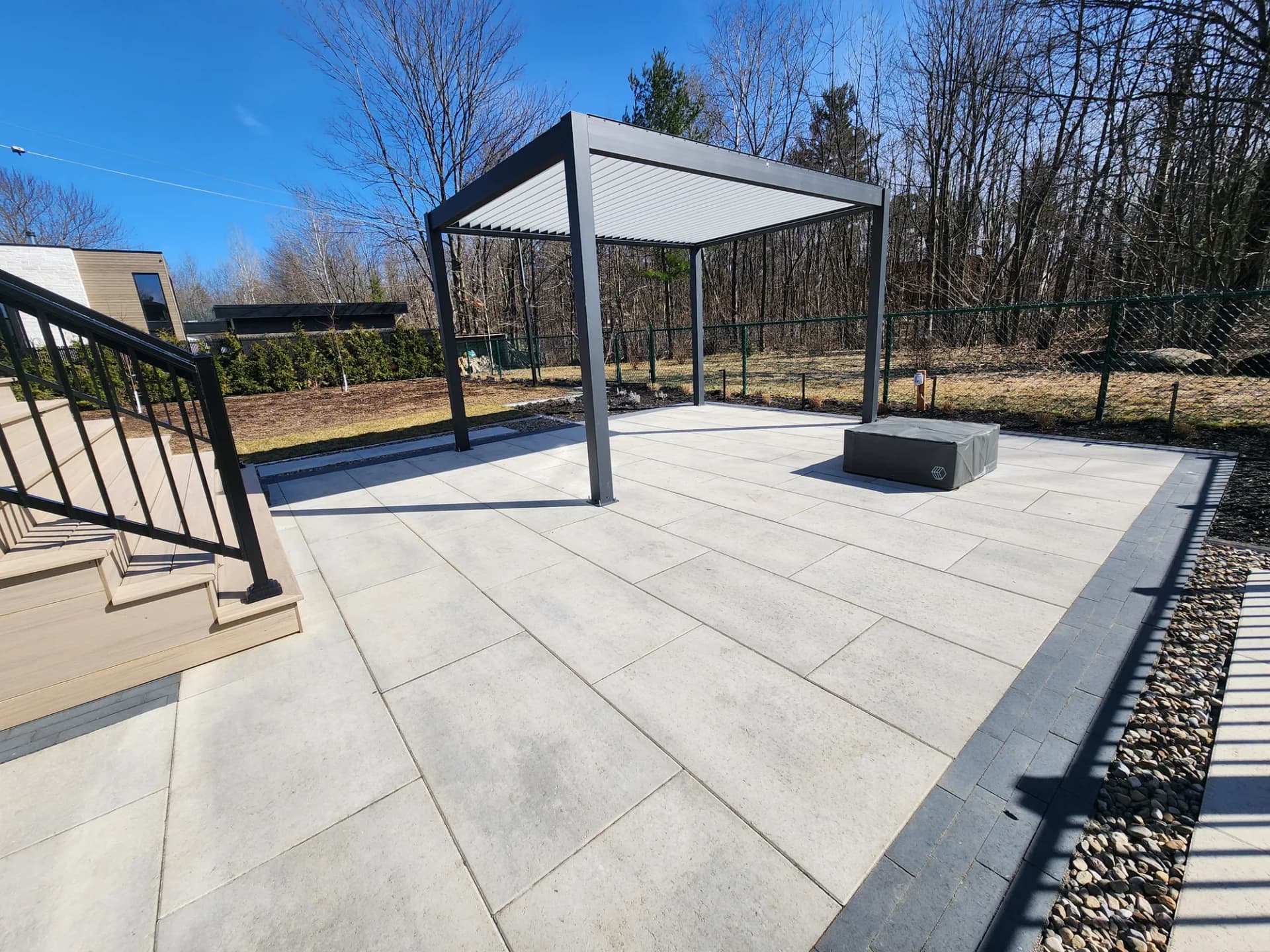 Pergola en aluminium à lames orientables sur un patio en dalles de porcelaine
