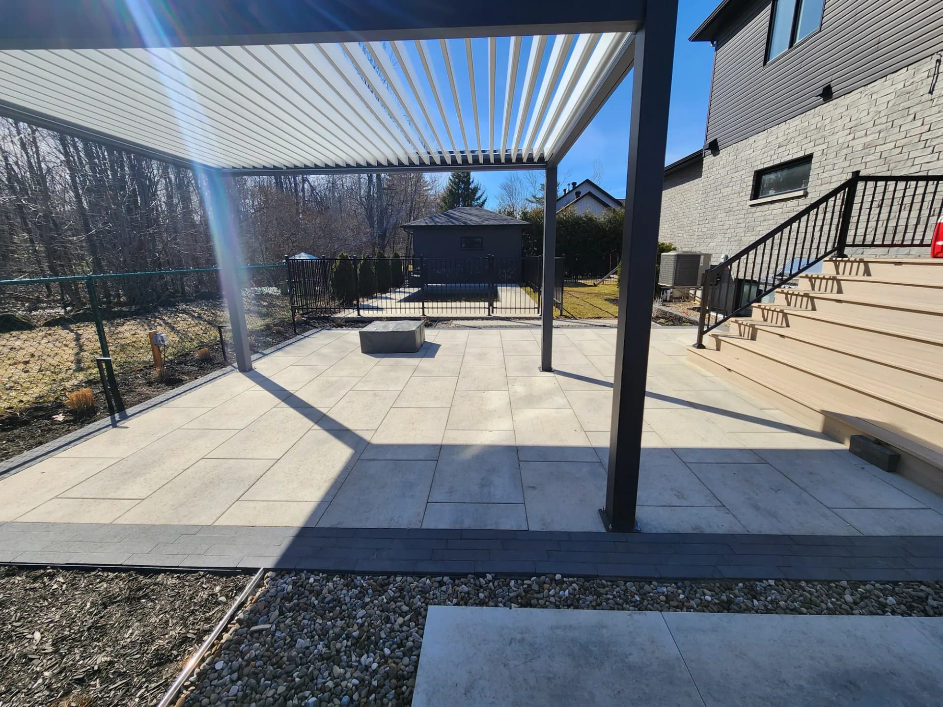 Terrasse en dalles avec pergola en aluminium et escalier en composite, Rive-Sud