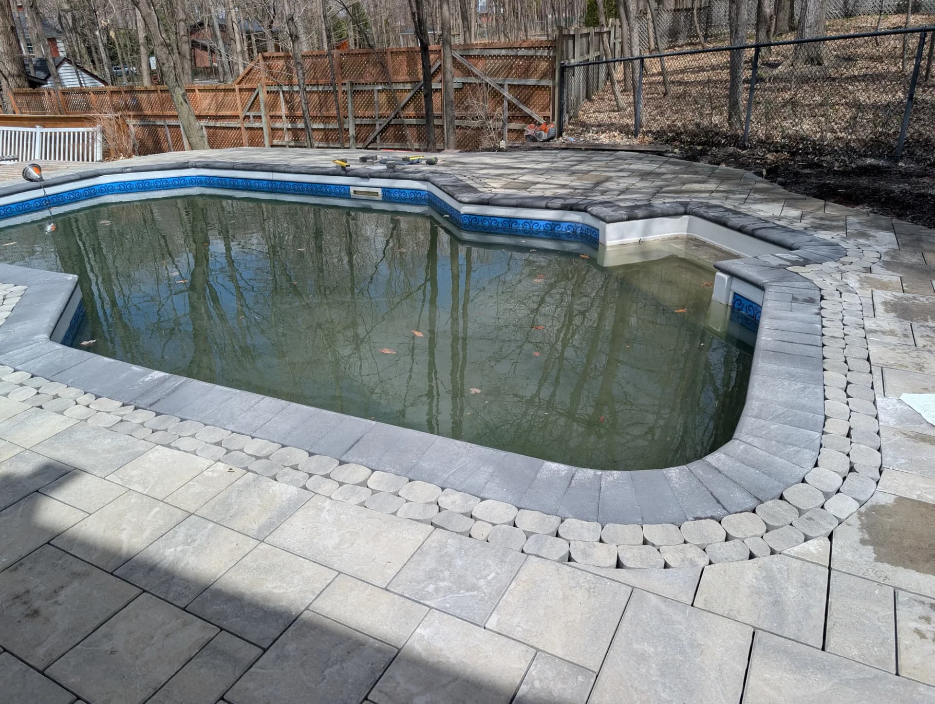 Contour de piscine creusée en pavé et pierre naturelle, aménagement Rive-Sud